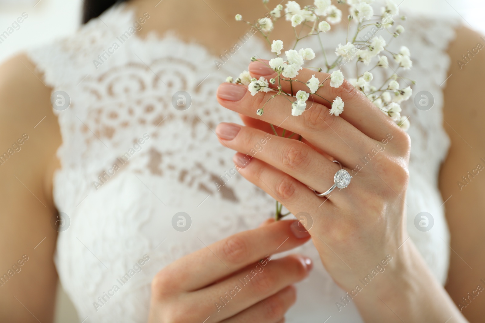 Photo of Young bride wearing beautiful engagement ring, closeup