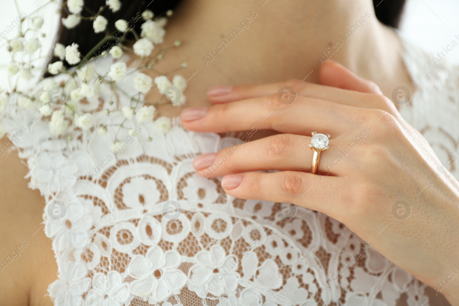 Photo of Young bride wearing beautiful engagement ring, closeup