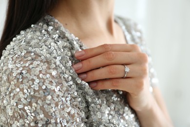 Photo of Young woman wearing beautiful engagement ring, closeup