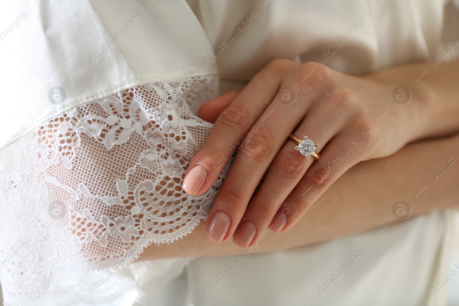 Photo of Young woman wearing beautiful engagement ring, closeup