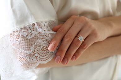 Photo of Young woman wearing beautiful engagement ring, closeup