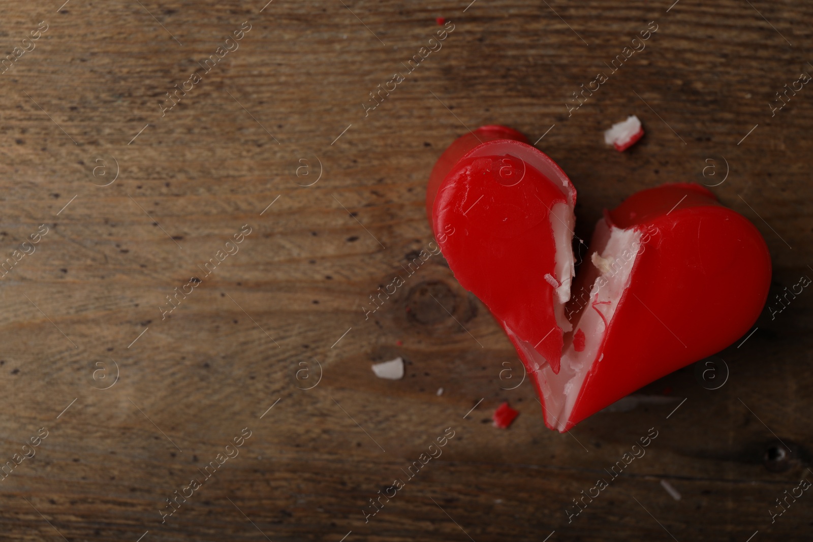 Photo of Broken heart shaped soap bar on wooden background, top view with space for text. Relationship problems concept