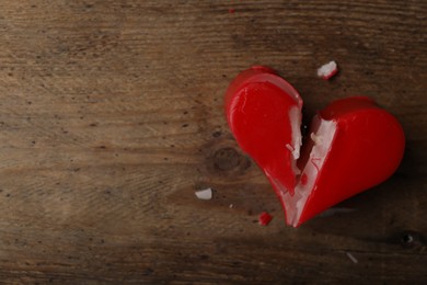 Photo of Broken heart shaped soap bar on wooden background, top view with space for text. Relationship problems concept