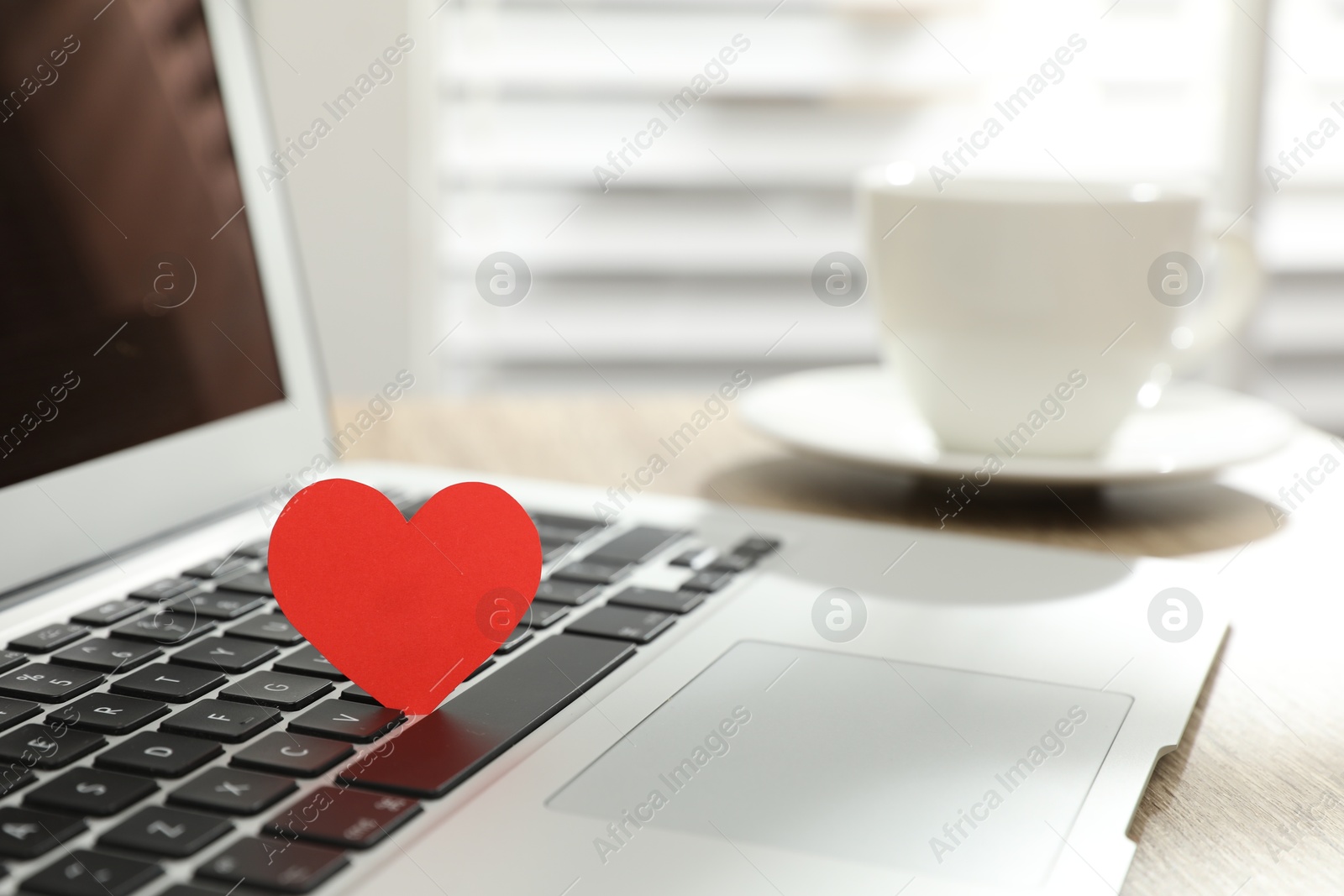 Photo of Red heart on laptop in office, space for text. Valentine's day celebration