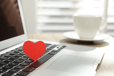 Photo of Red heart on laptop in office, space for text. Valentine's day celebration