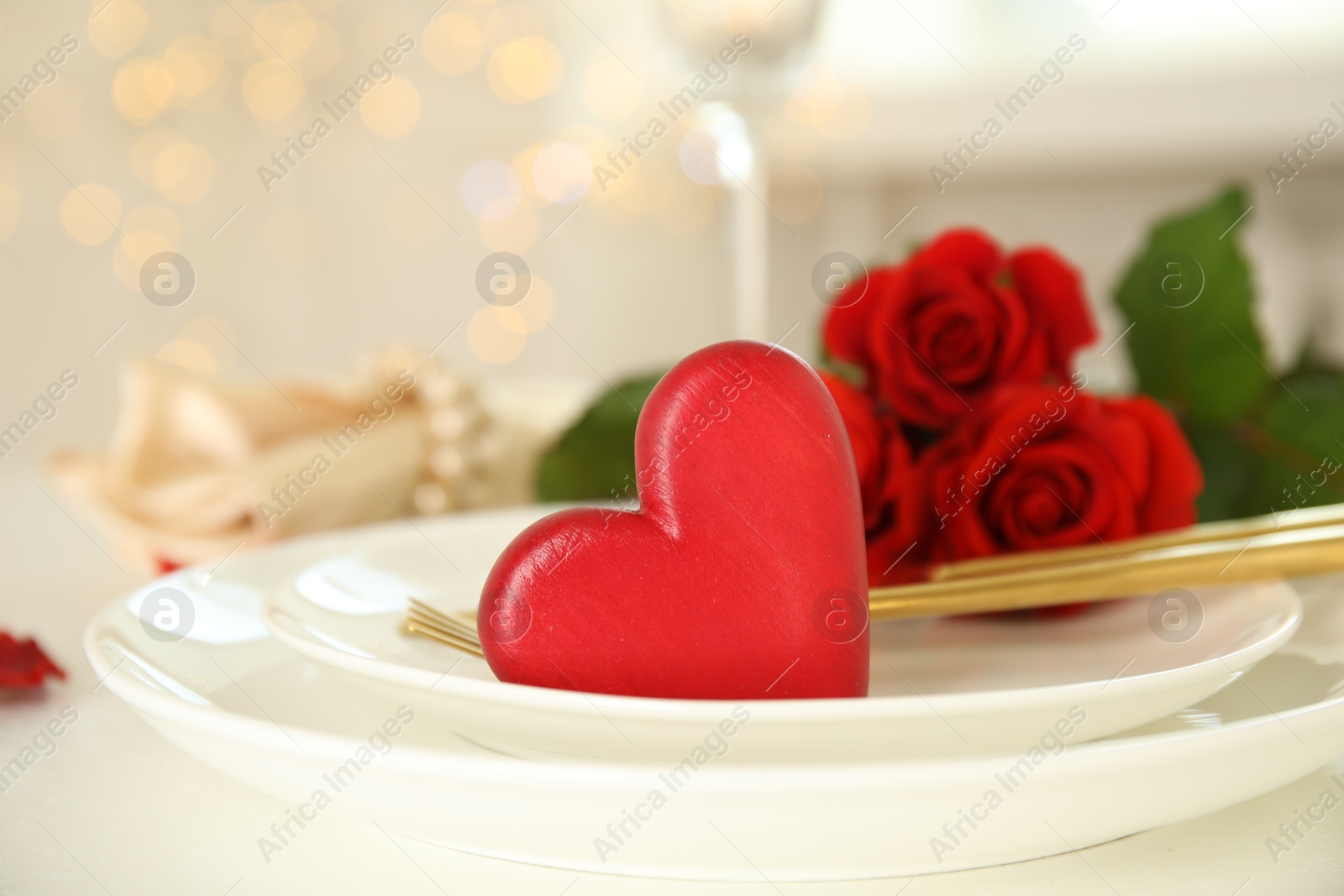 Photo of Elegant table setting for romantic dinner against blurred lights. Valentine's day celebration