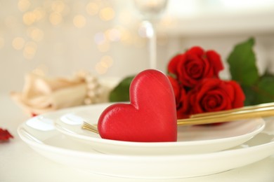 Elegant table setting for romantic dinner against blurred lights. Valentine's day celebration