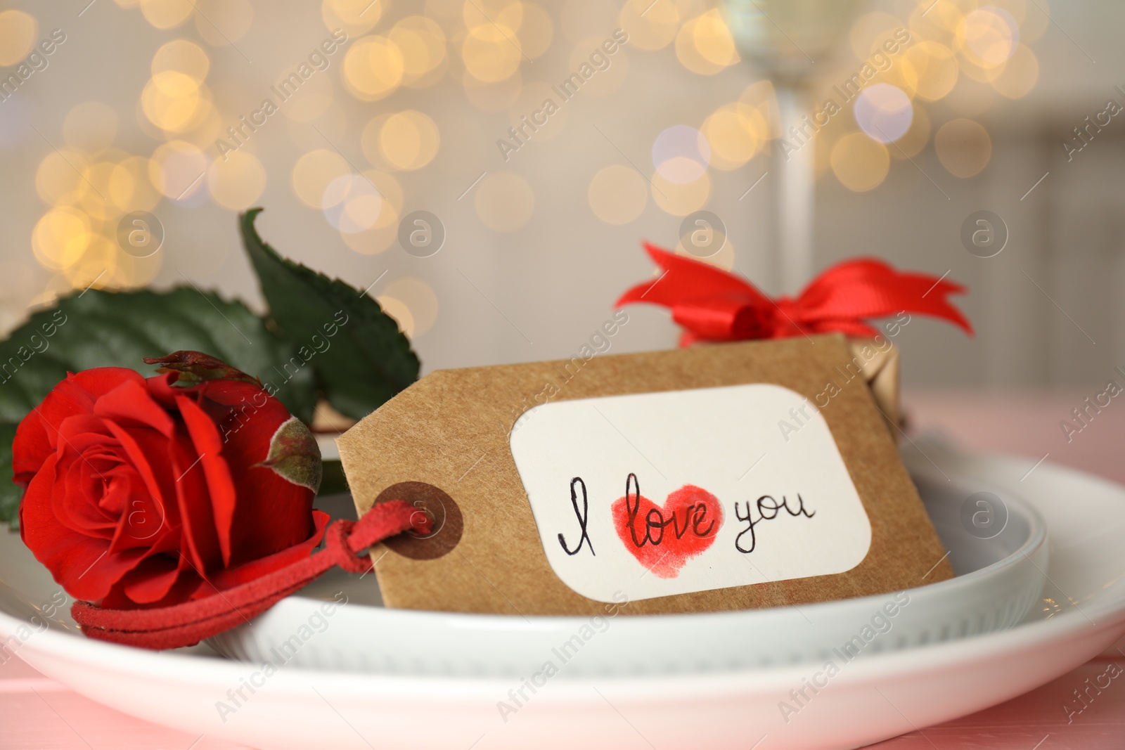 Photo of Elegant place setting for romantic dinner on pink table, closeup. Valentine's day celebration