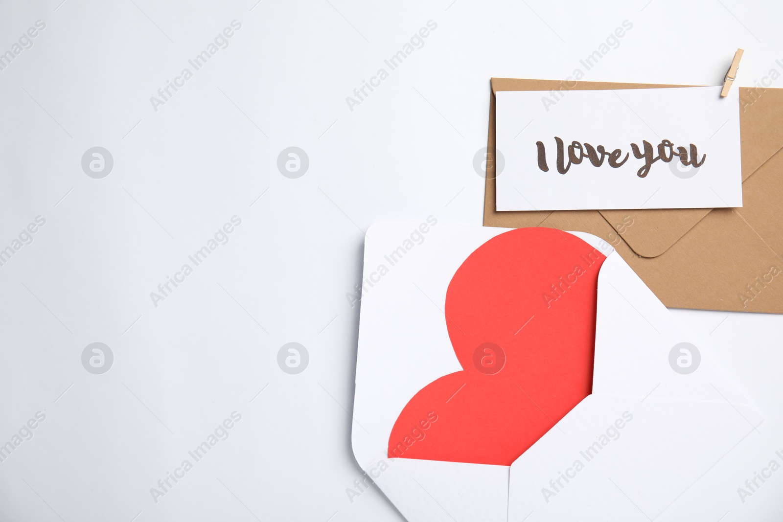 Photo of Card with phrase I Love You, envelopes and red heart on white background, flat lay. Space for text