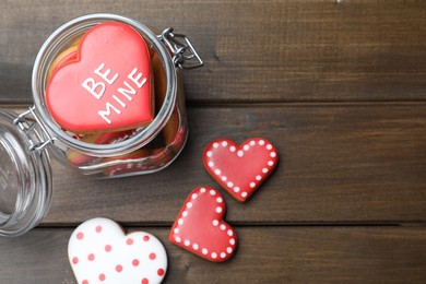 Photo of Delicious heart shaped cookies on wooden table, flat lay. Valentine's Day