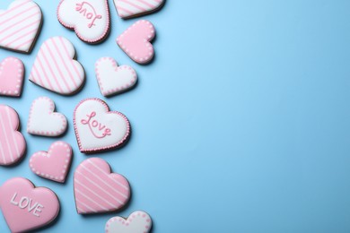 Photo of Delicious heart shaped cookies on light blue background, flat lay with space for text. Valentine's Day