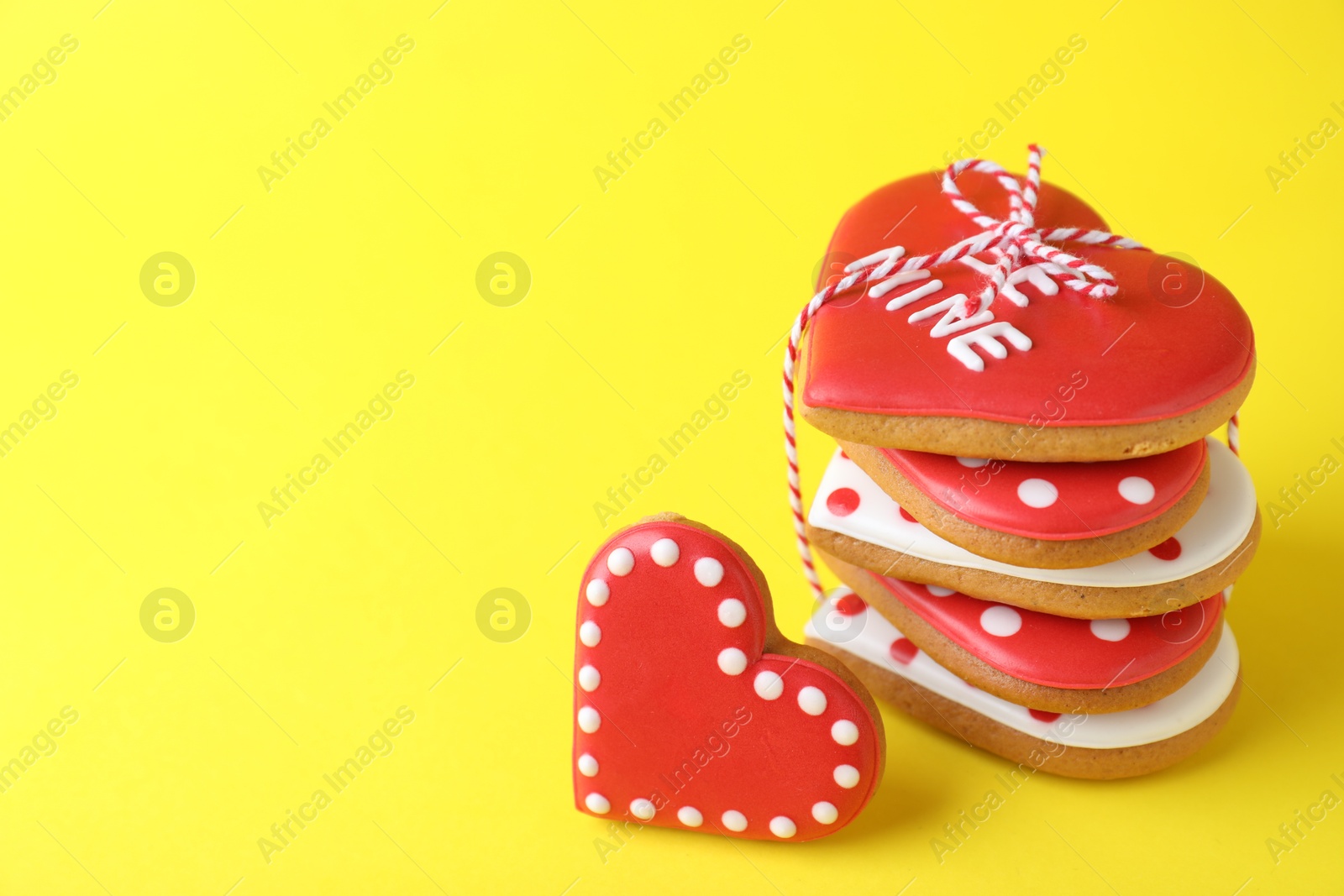 Photo of Gift set of heart shaped cookies on yellow background, closeup with space for text. Valentine's day treat