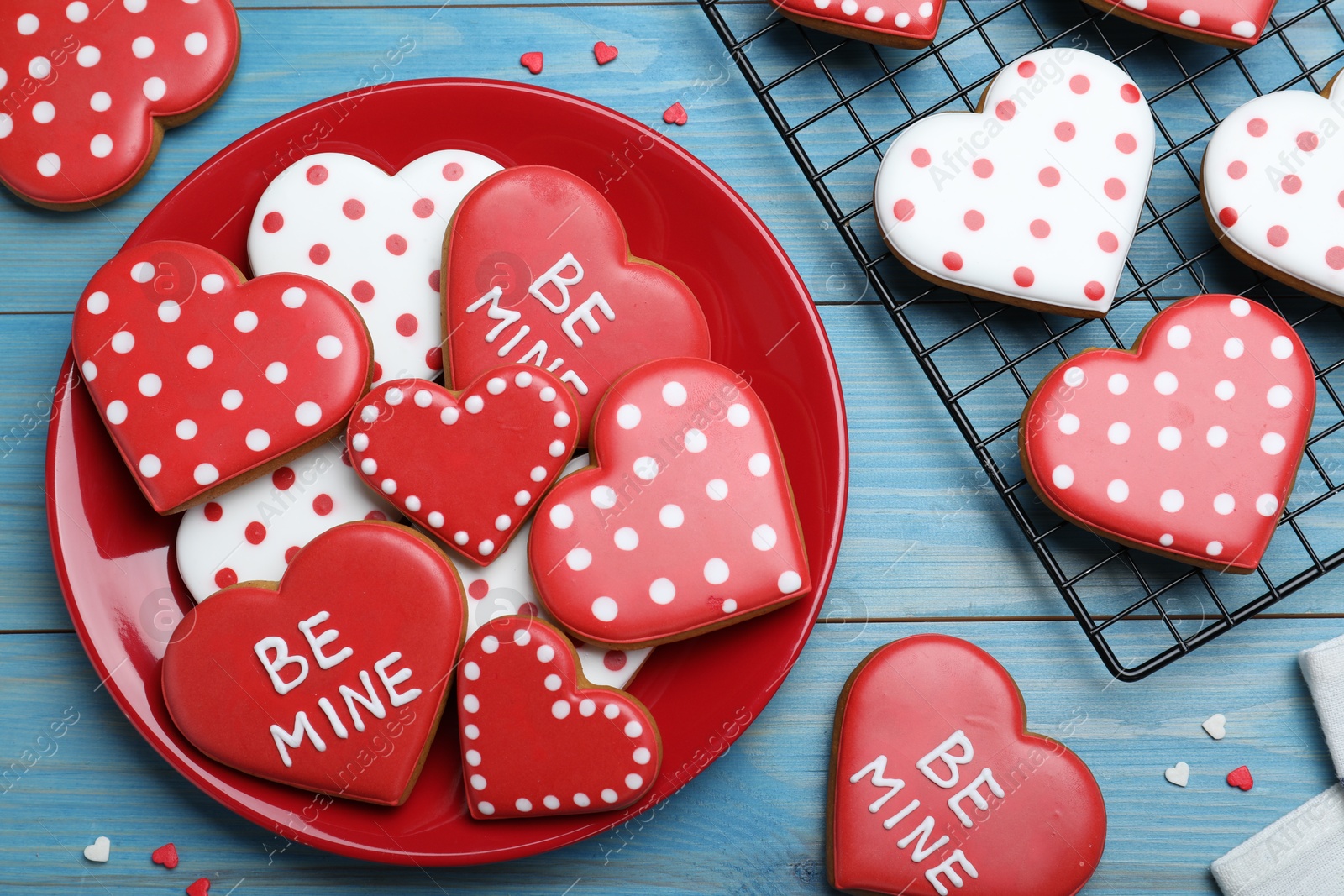 Photo of Decorated heart shaped cookies on blue wooden table, flat lay. Valentine's day treat