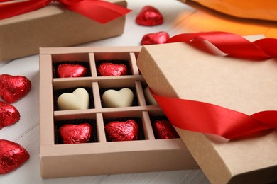 Photo of Tasty heart shaped chocolate candies on white wooden table. Happy Valentine's day