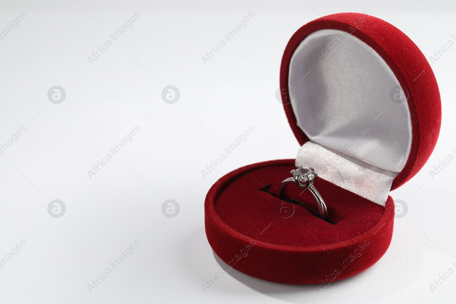 Photo of Beautiful engagement ring in red box on white background, space for text