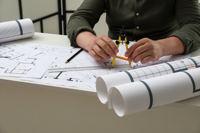 Photo of Architect working with project, closeup. Different technical drawings on table