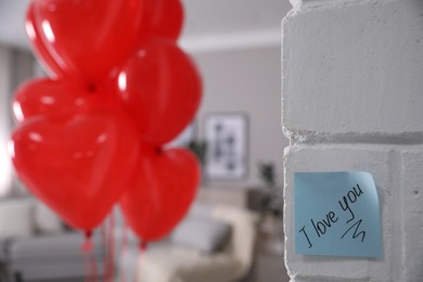 Photo of Paper note with handwritten words I Love You on white brick wall indoors. Space for text