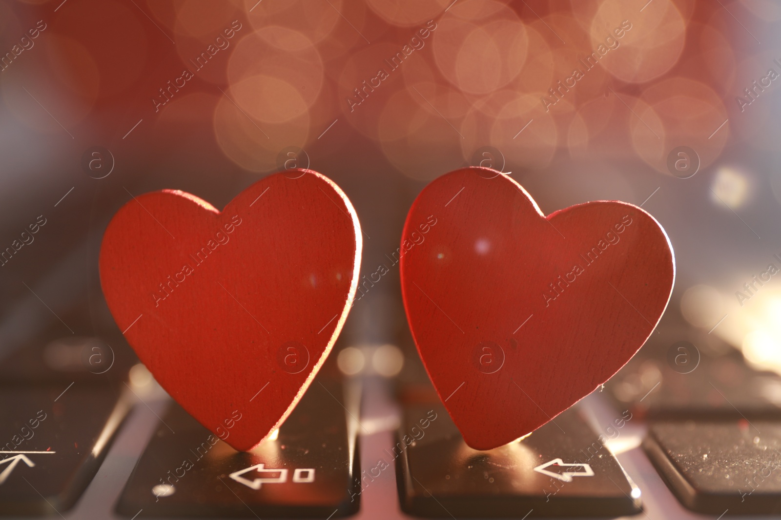 Photo of Decorative hearts on laptop keyboard, closeup. Online dating concept