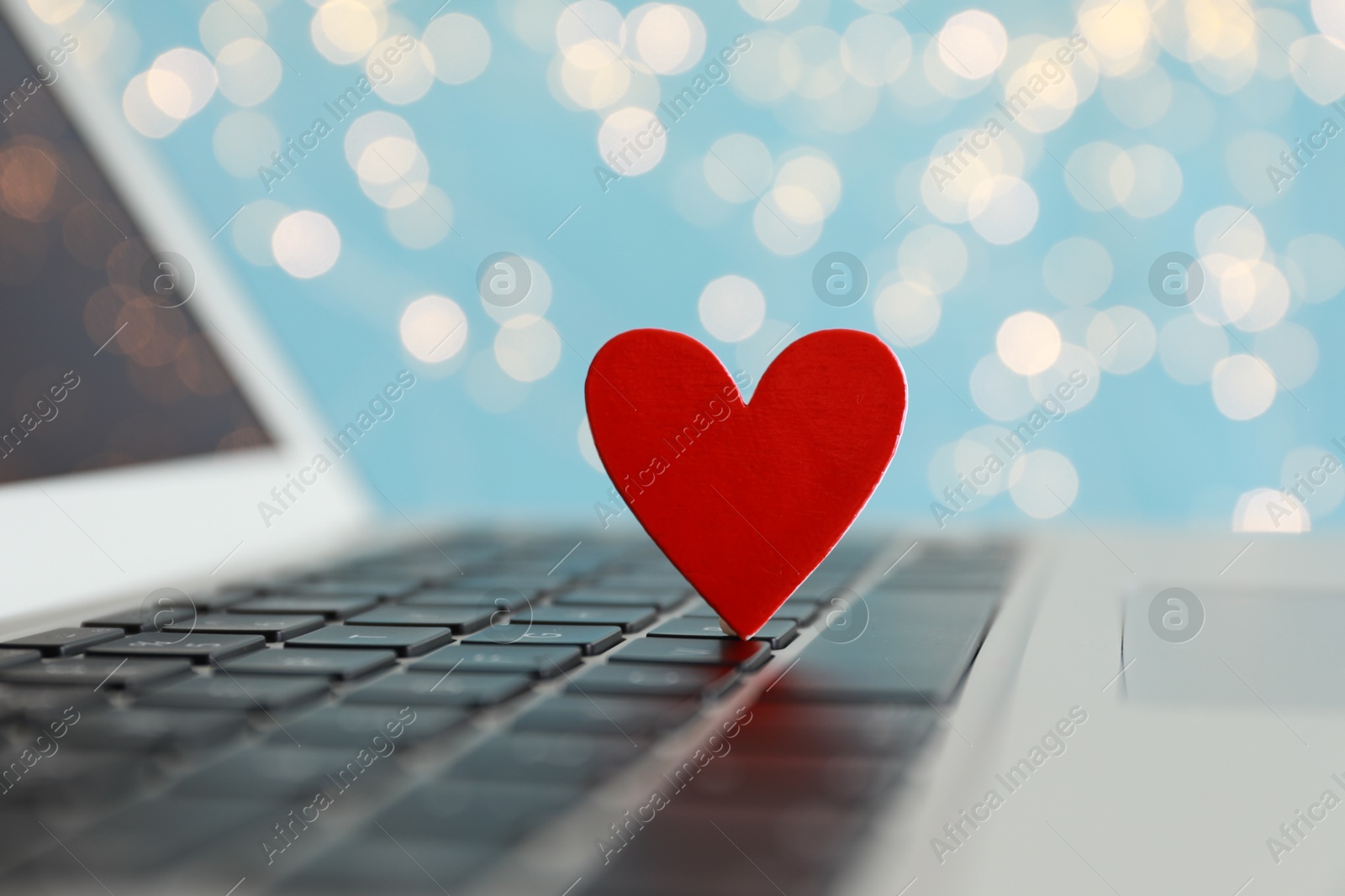 Photo of Decorative heart on laptop keyboard, closeup. Online dating concept