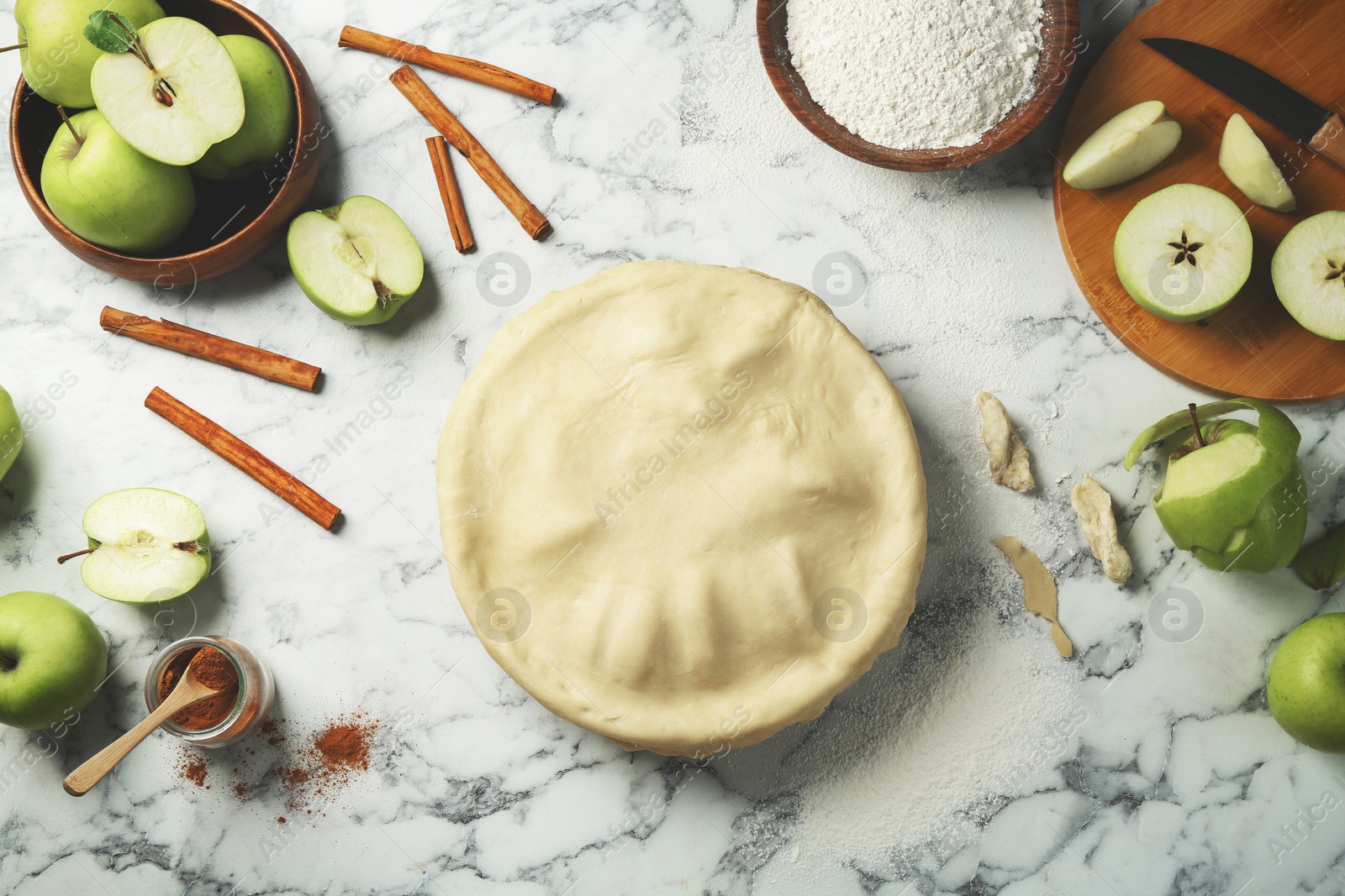 Photo of Flat lay composition with raw homemade apple pie and ingredients on white marble table