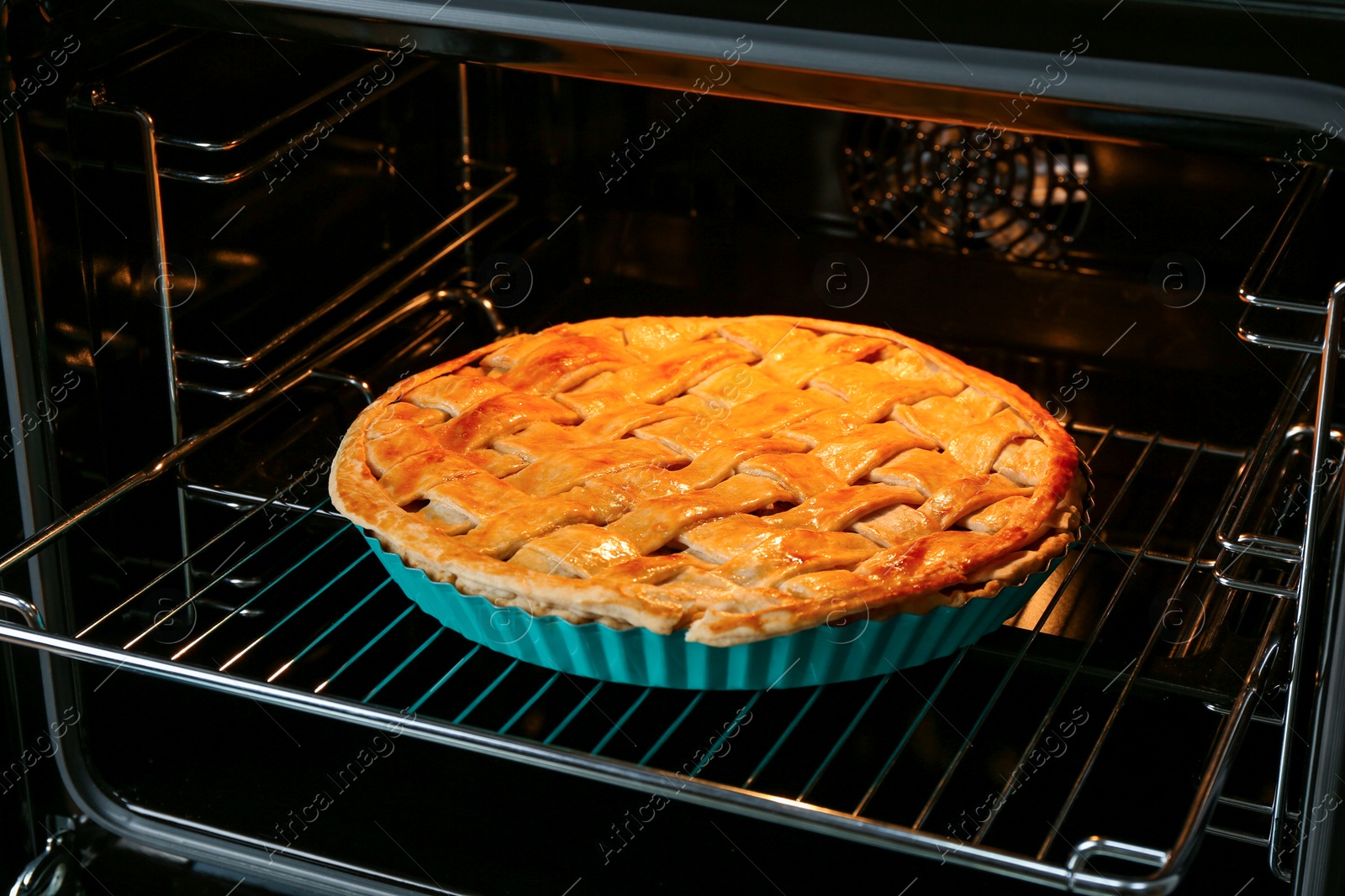 Photo of Baking dish with homemade apple pie in oven