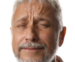 Photo of Sad senior man crying on white background, closeup