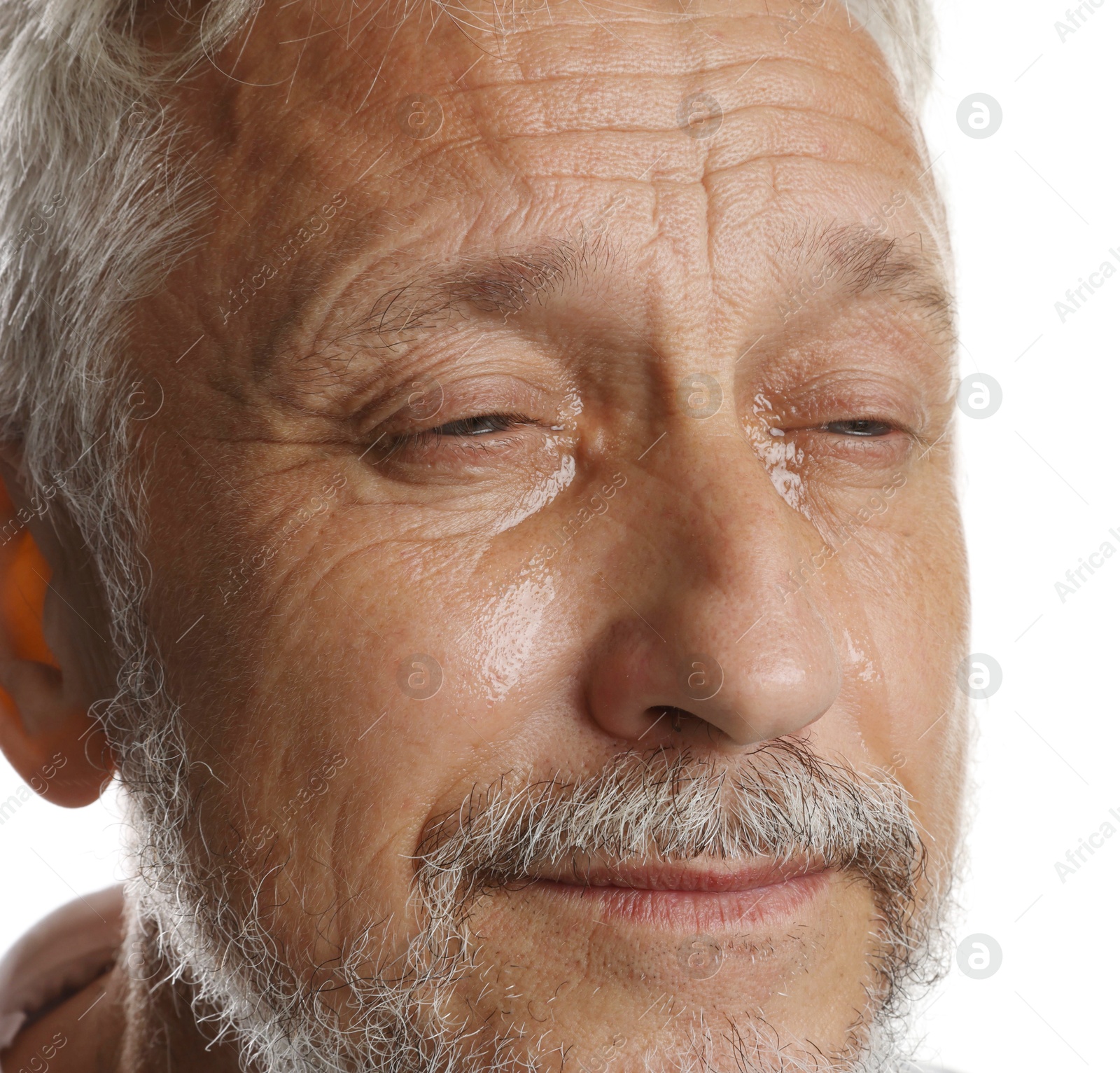 Photo of Sad senior man crying on white background, closeup