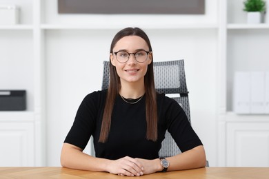 Photo of Portrait of businesswoman at wooden table in office