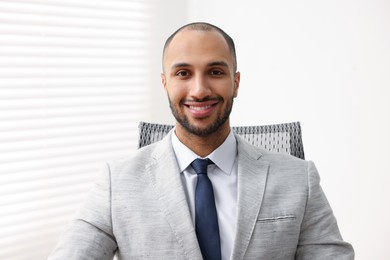 Portrait of happy businessman in jacket indoors