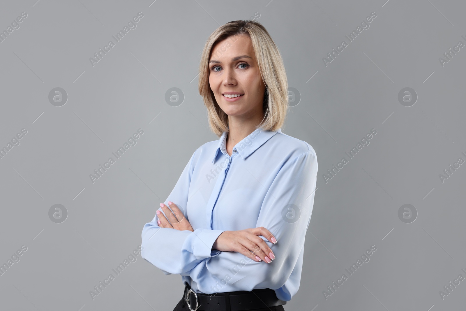 Photo of Portrait of businesswoman in light blue shirt on gray background