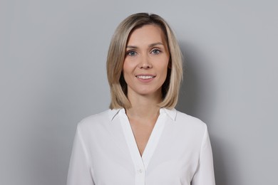 Photo of Portrait of businesswoman in white shirt on gray background