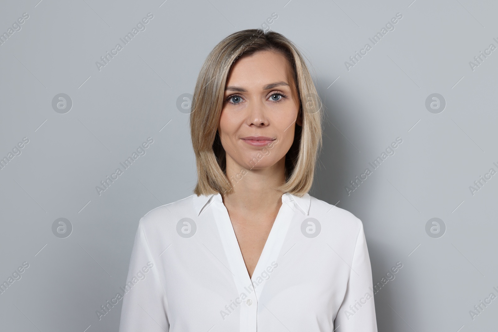 Photo of Portrait of businesswoman in white shirt on gray background