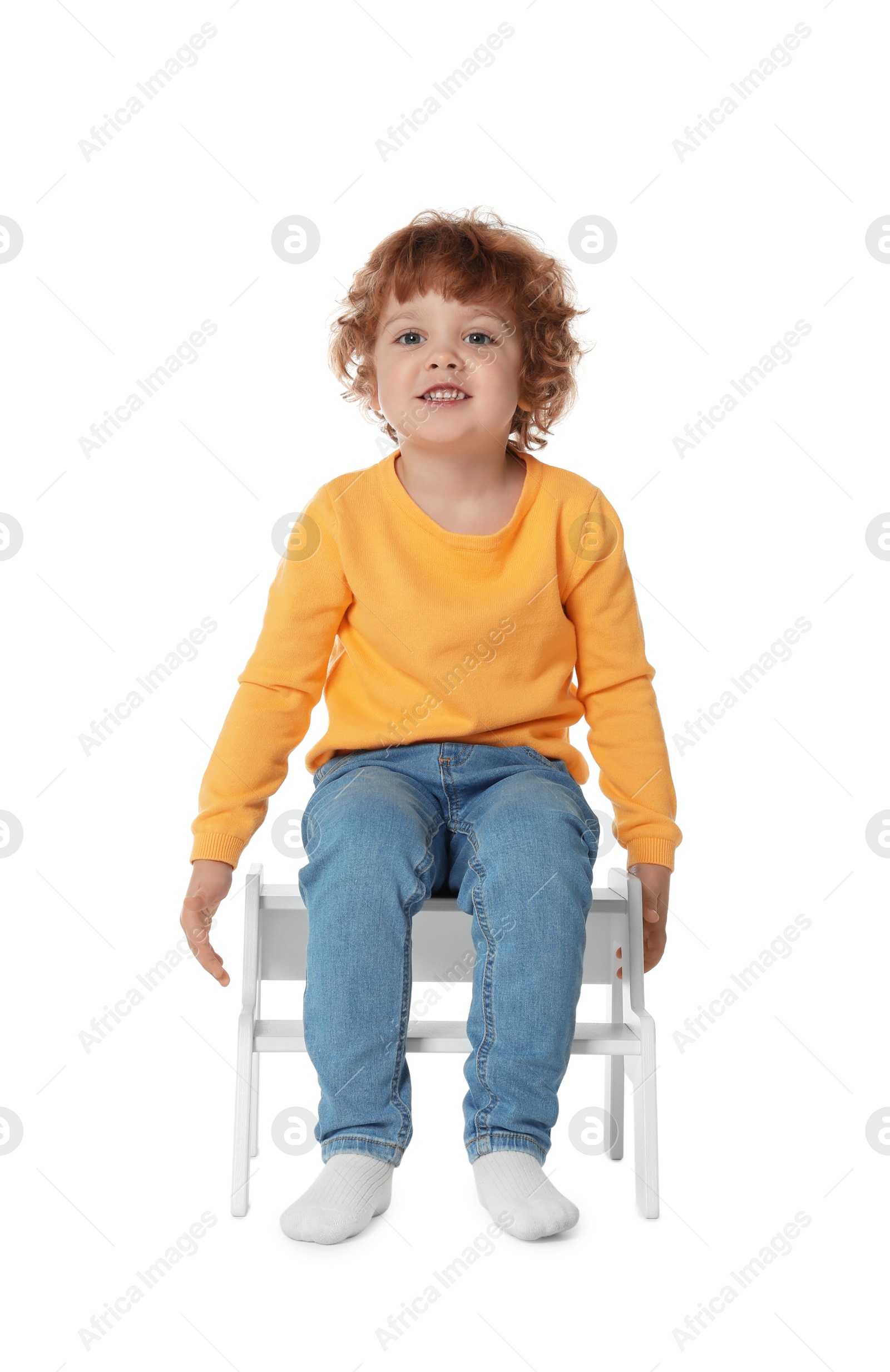 Photo of Little boy sitting on step stool against white background