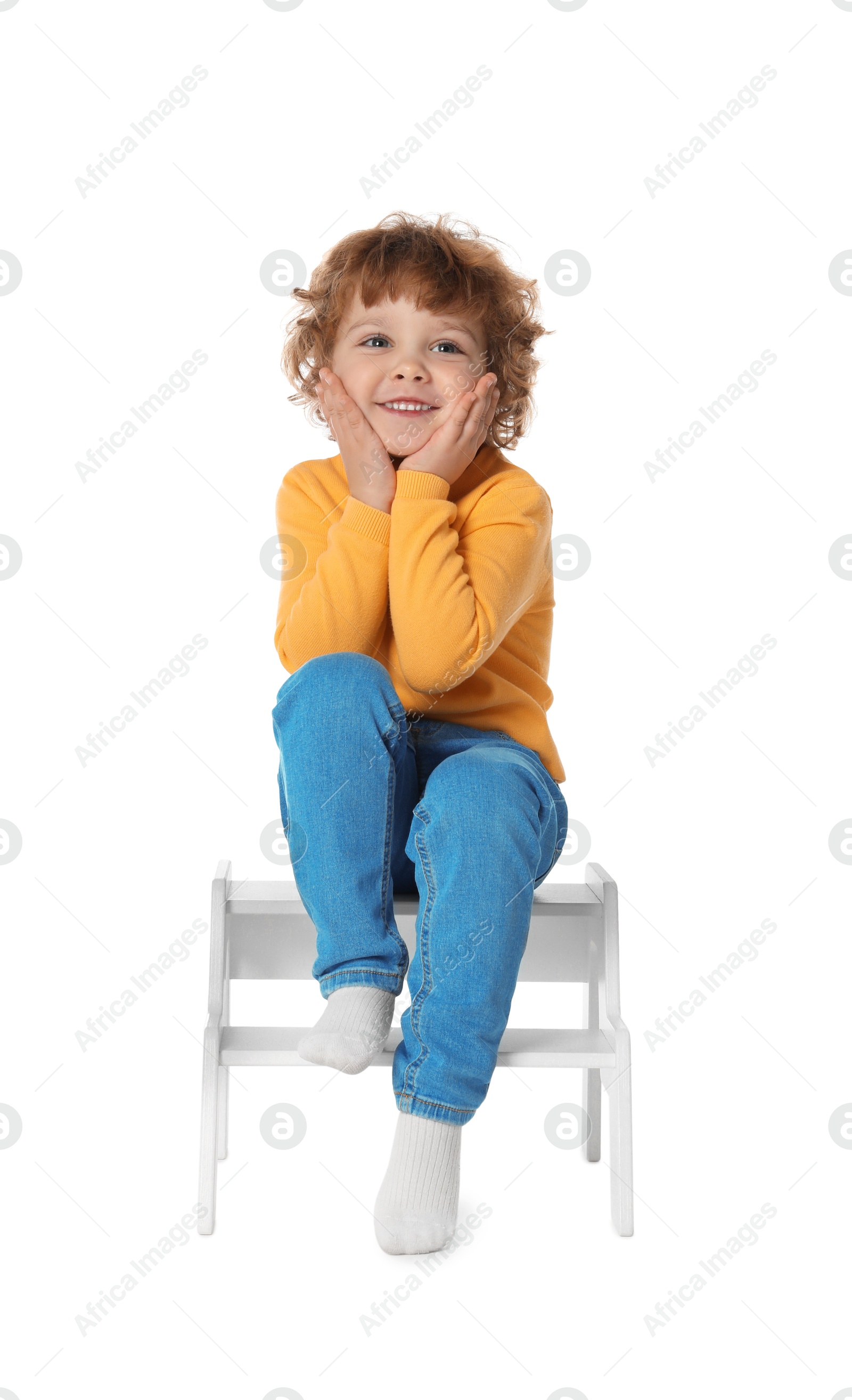 Photo of Little boy sitting on step stool against white background