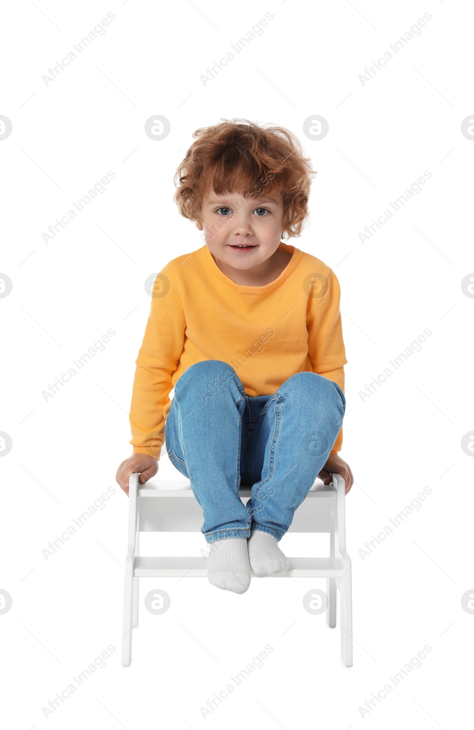 Photo of Little boy sitting on step stool against white background