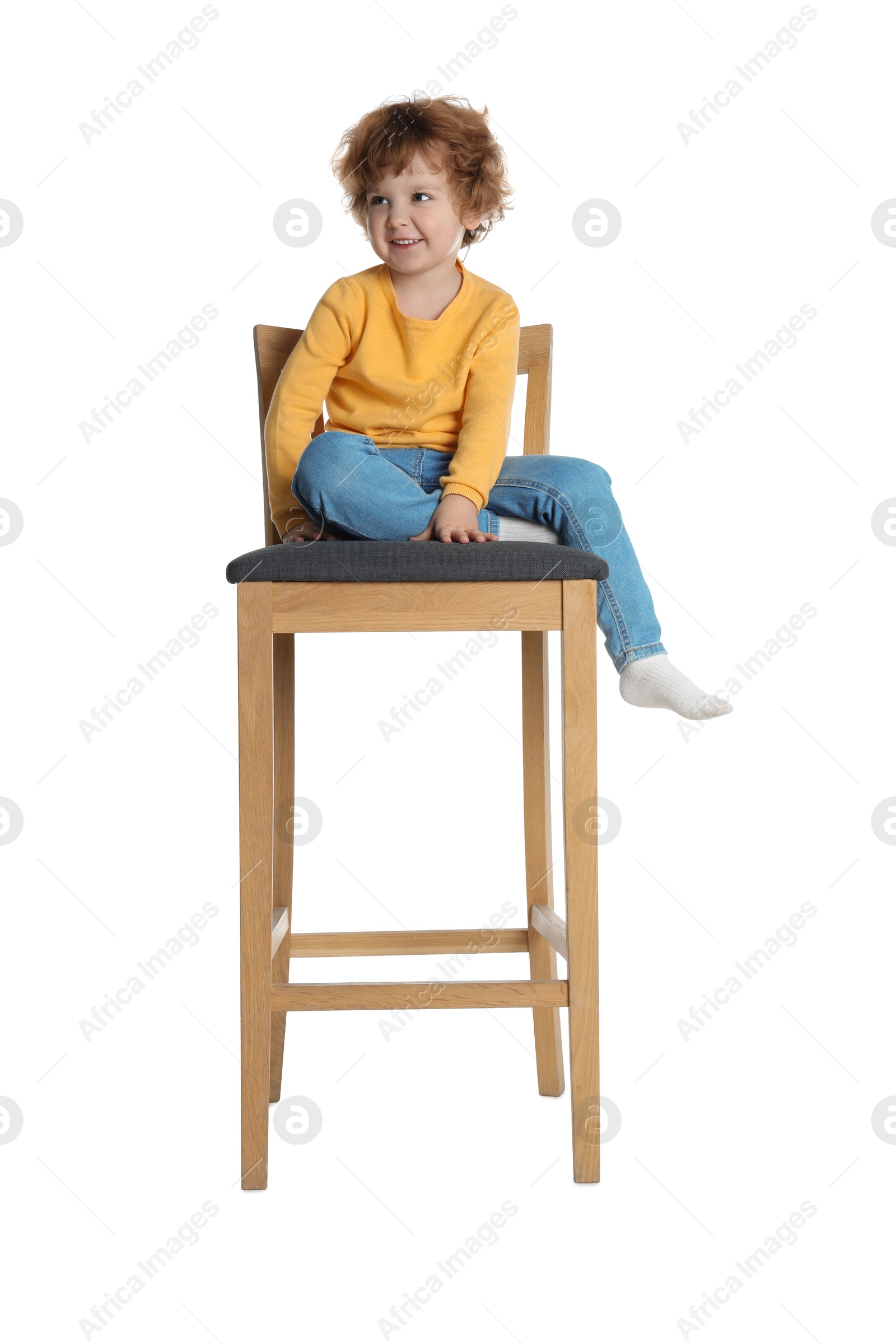 Photo of Little boy sitting on stool against white background