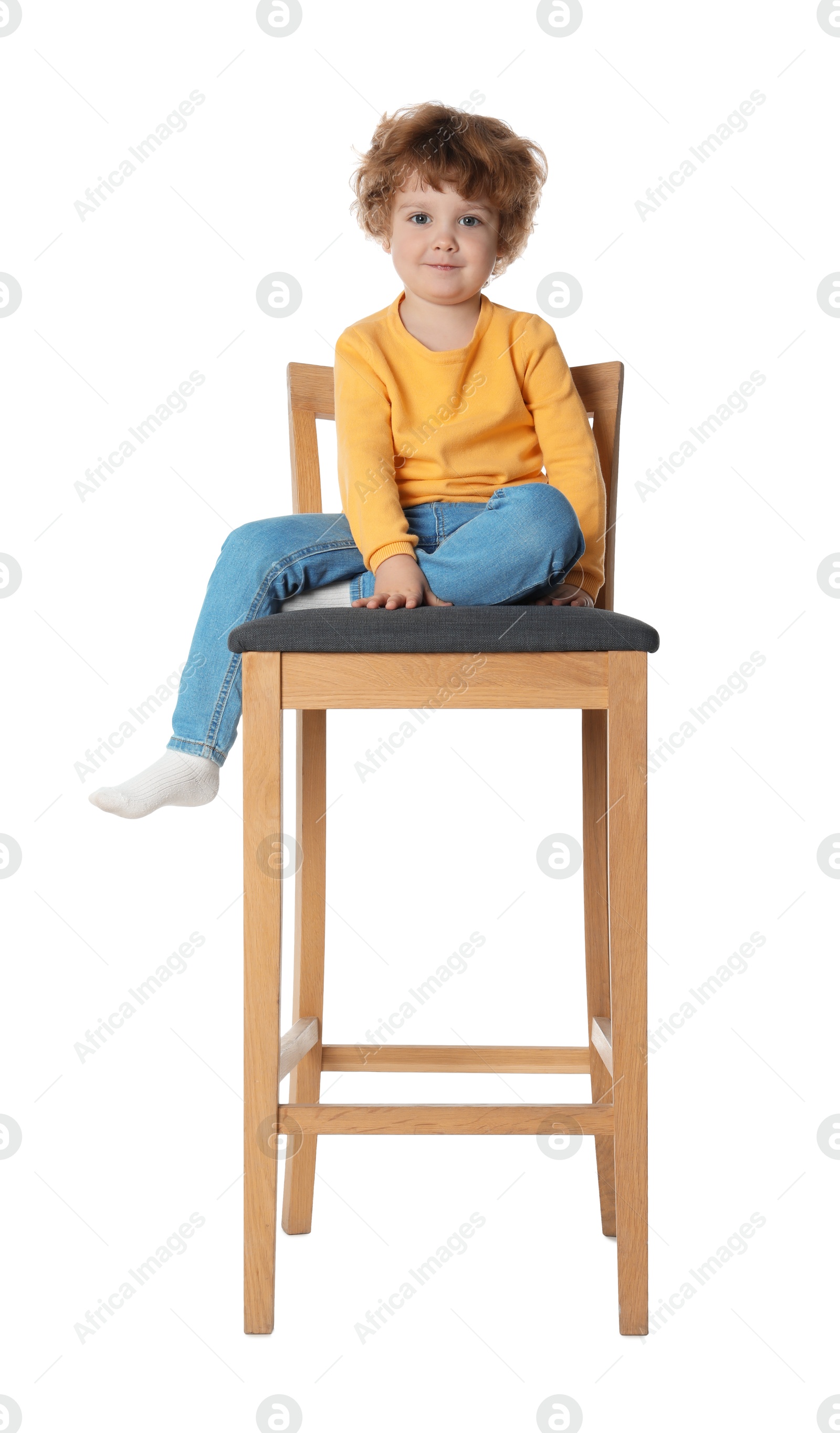 Photo of Little boy sitting on stool against white background