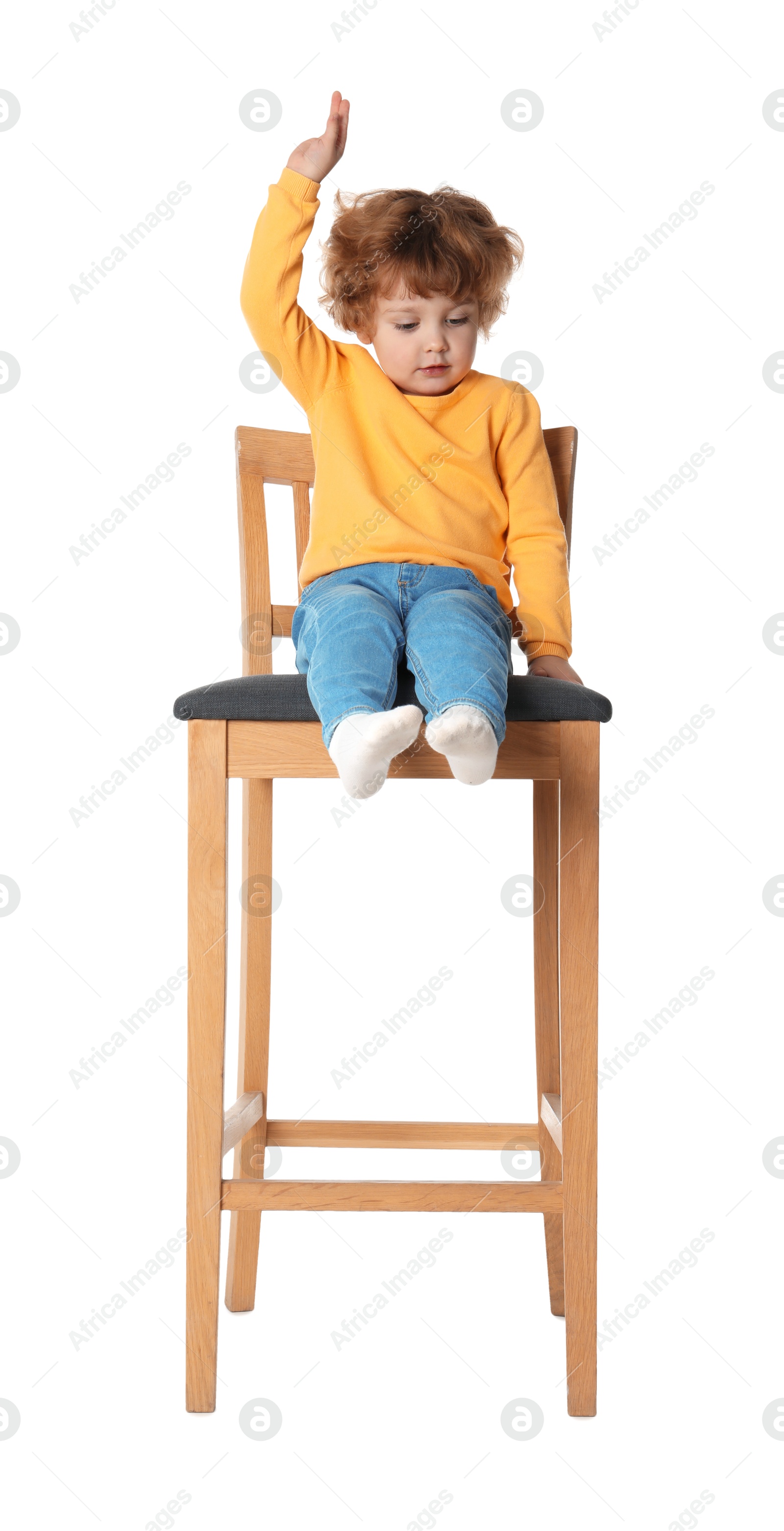 Photo of Little boy sitting on stool against white background