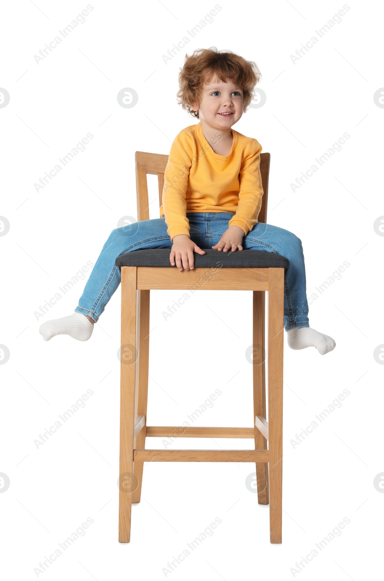 Photo of Little boy sitting on stool against white background