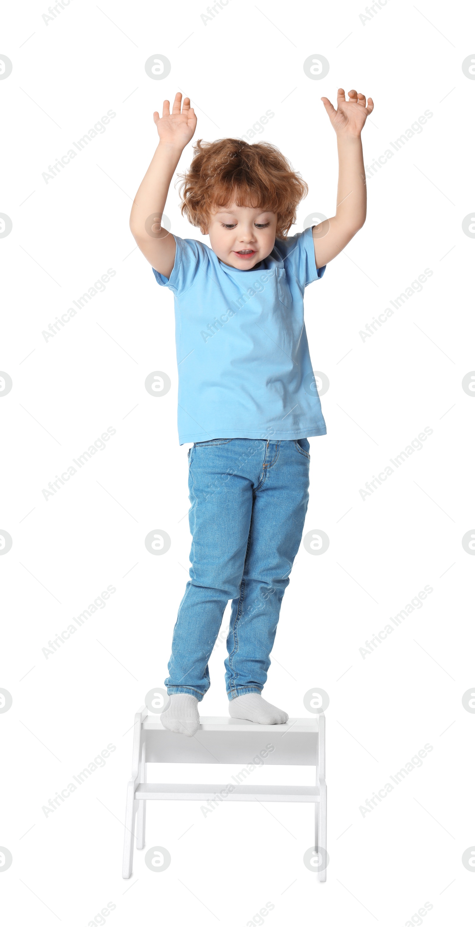 Photo of Little boy standing on step stool against white background