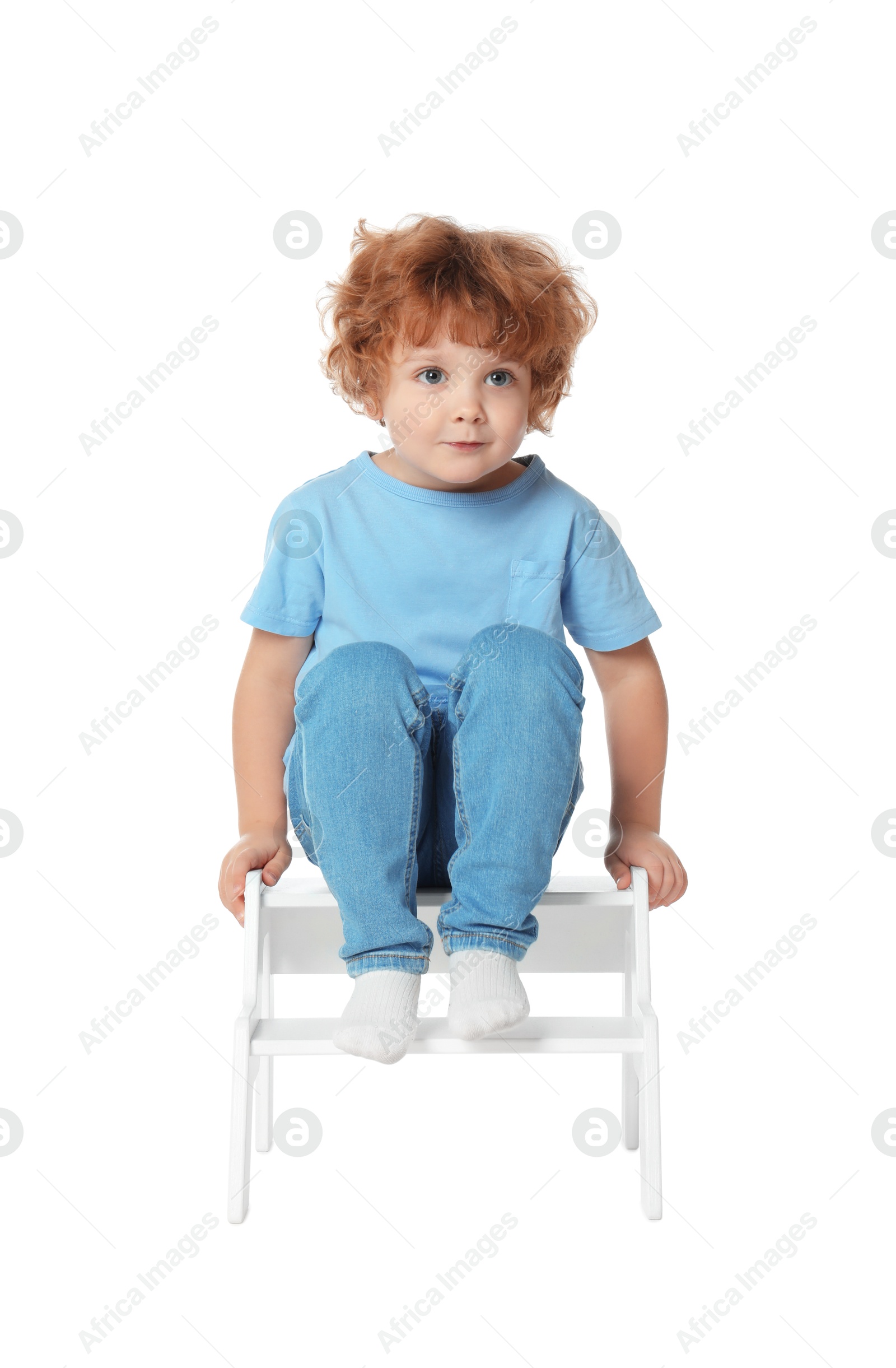 Photo of Little boy sitting on step stool against white background