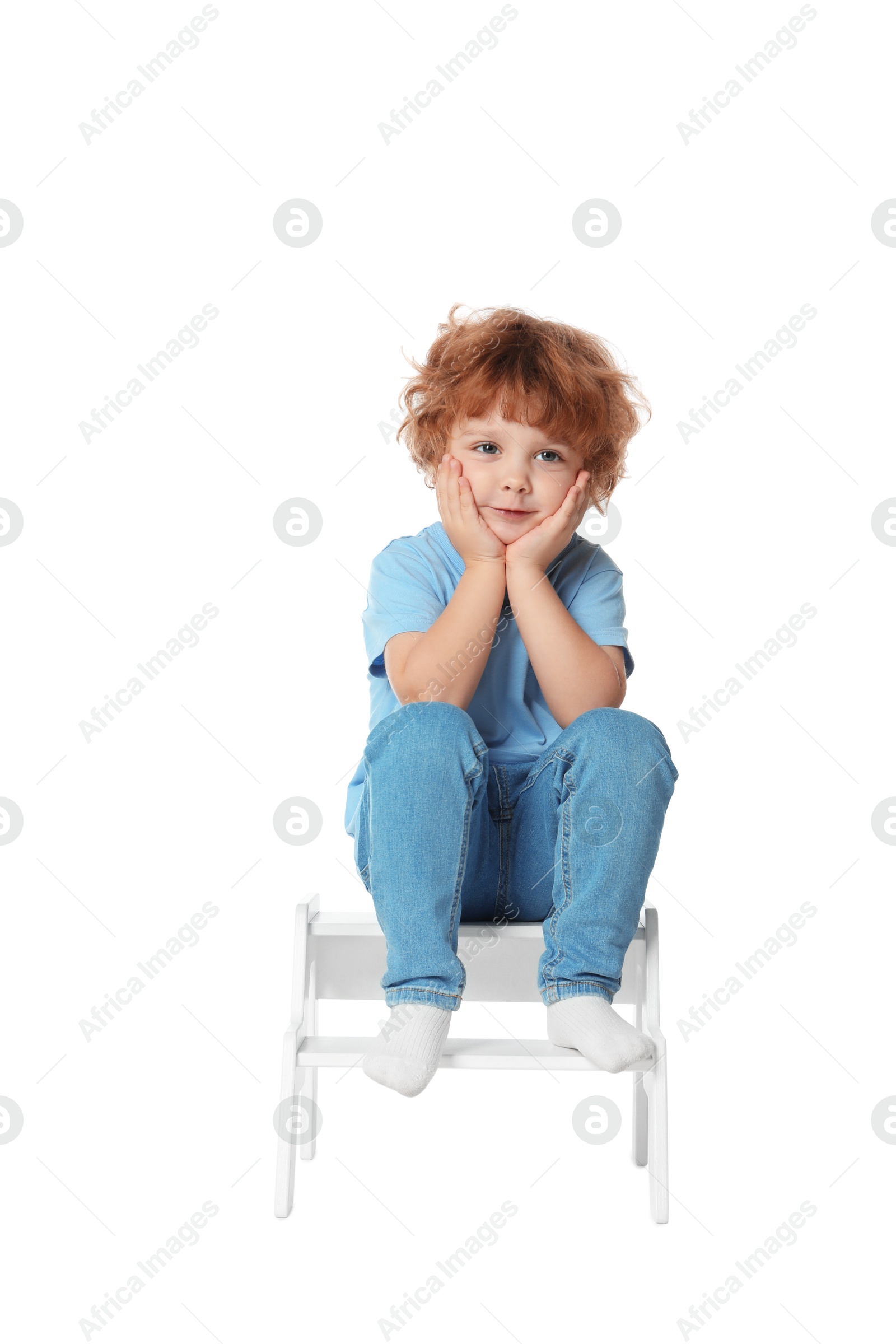 Photo of Little boy sitting on step stool against white background