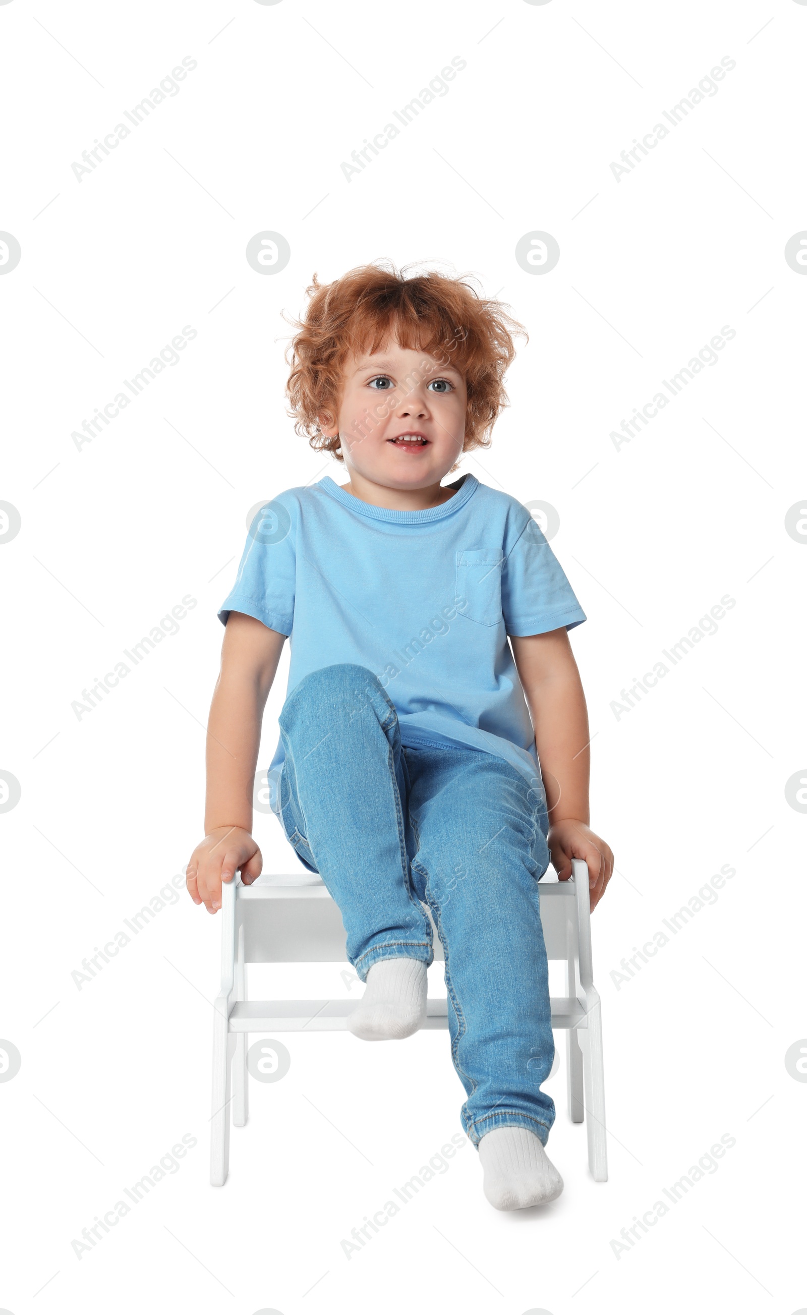 Photo of Little boy sitting on step stool against white background