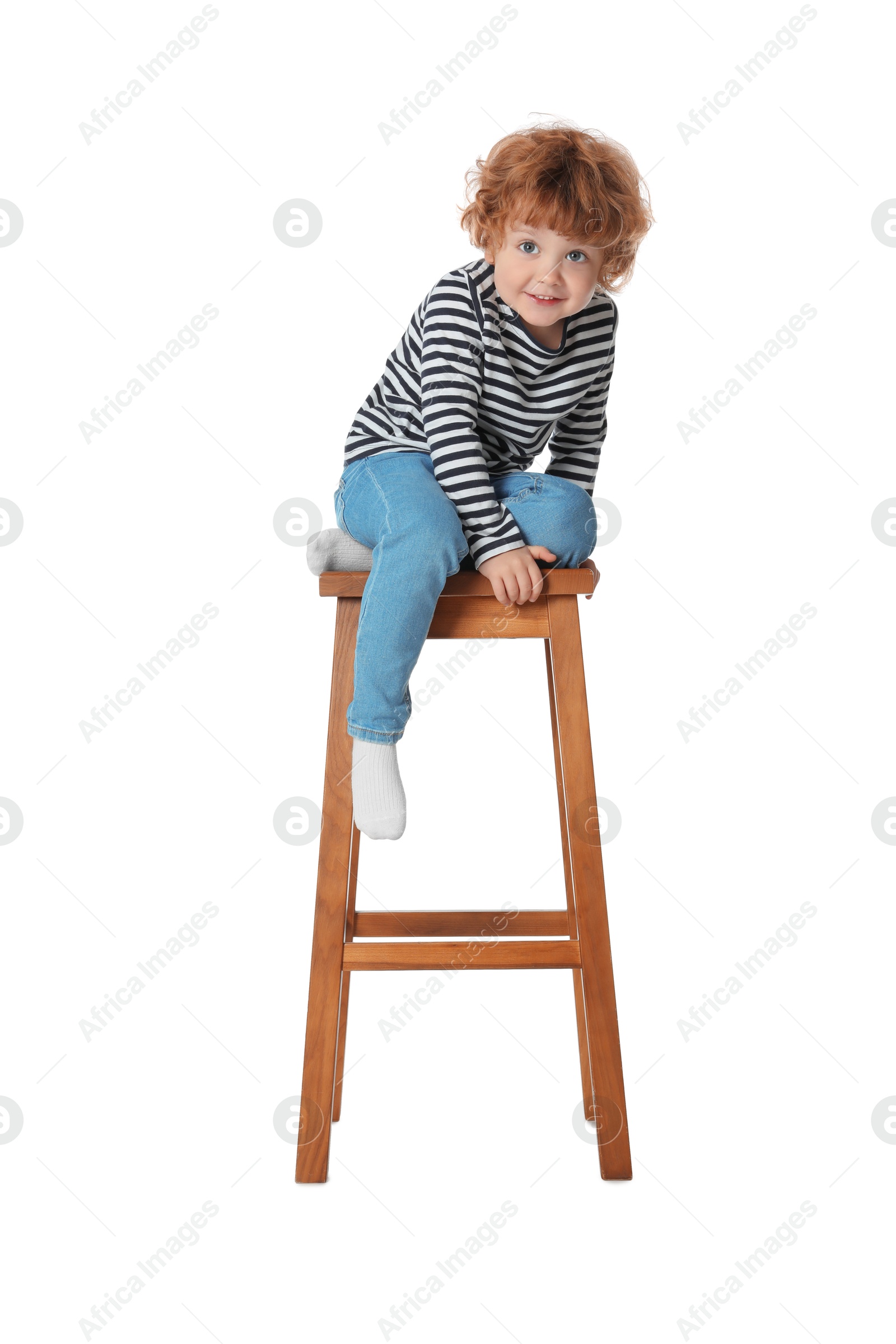 Photo of Little boy sitting on stool against white background