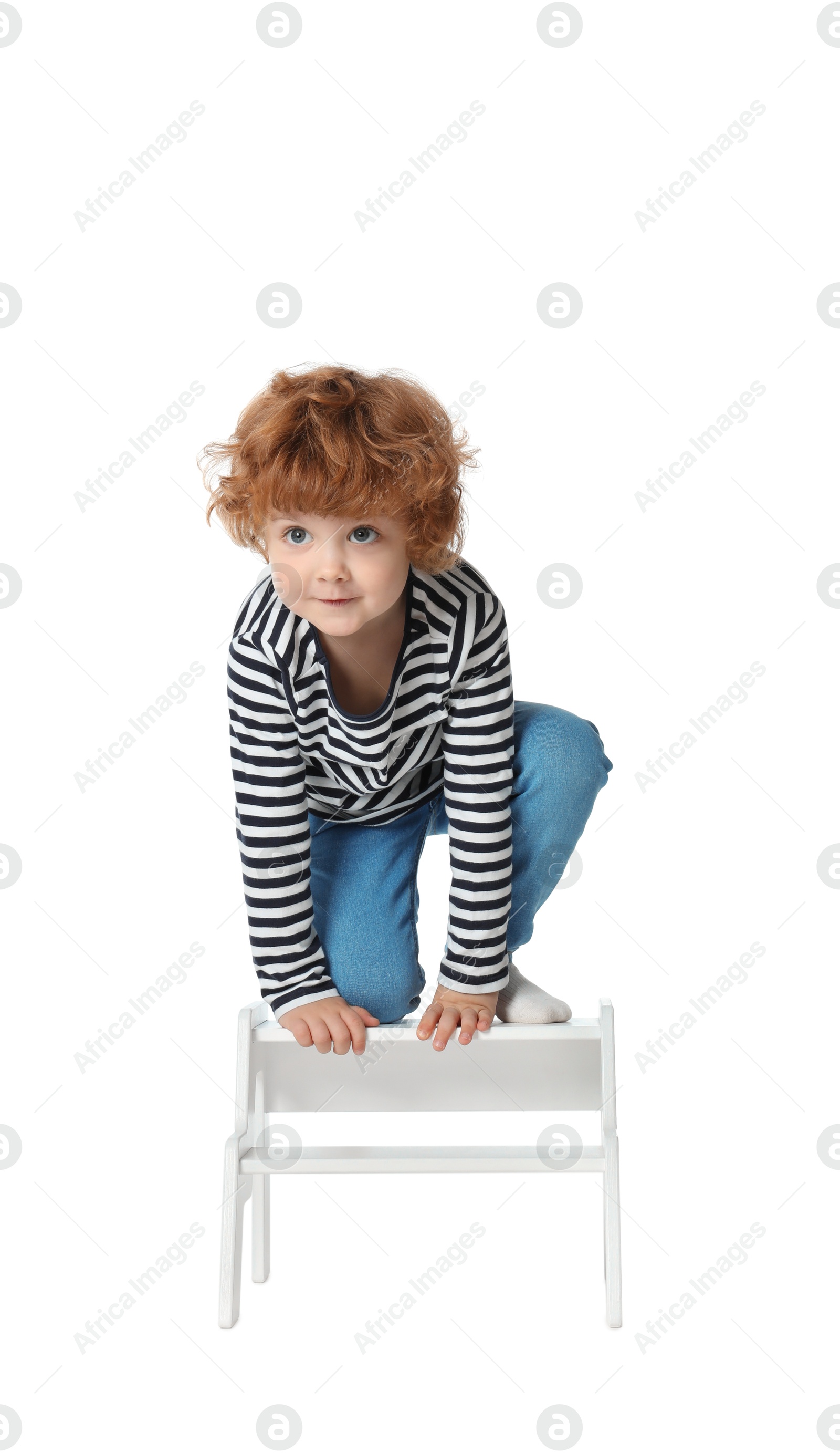 Photo of Little boy standing on step stool against white background