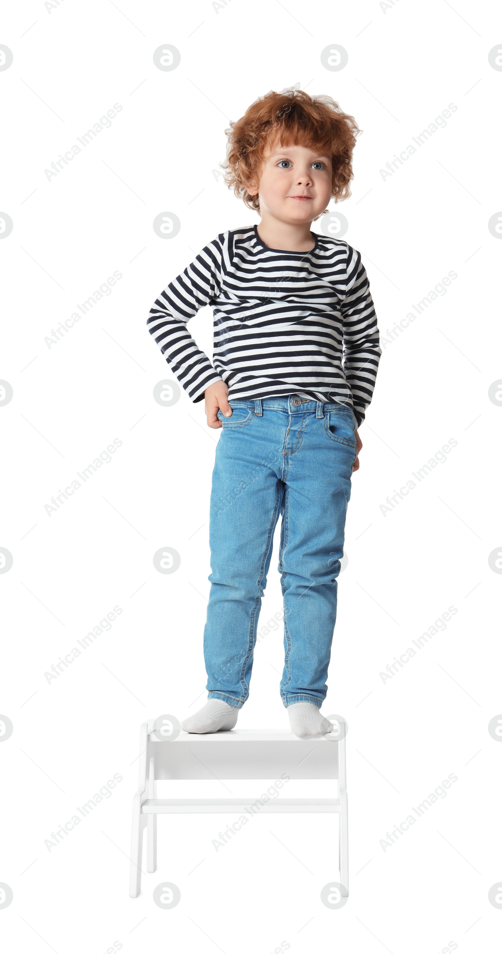 Photo of Little boy standing on step stool against white background