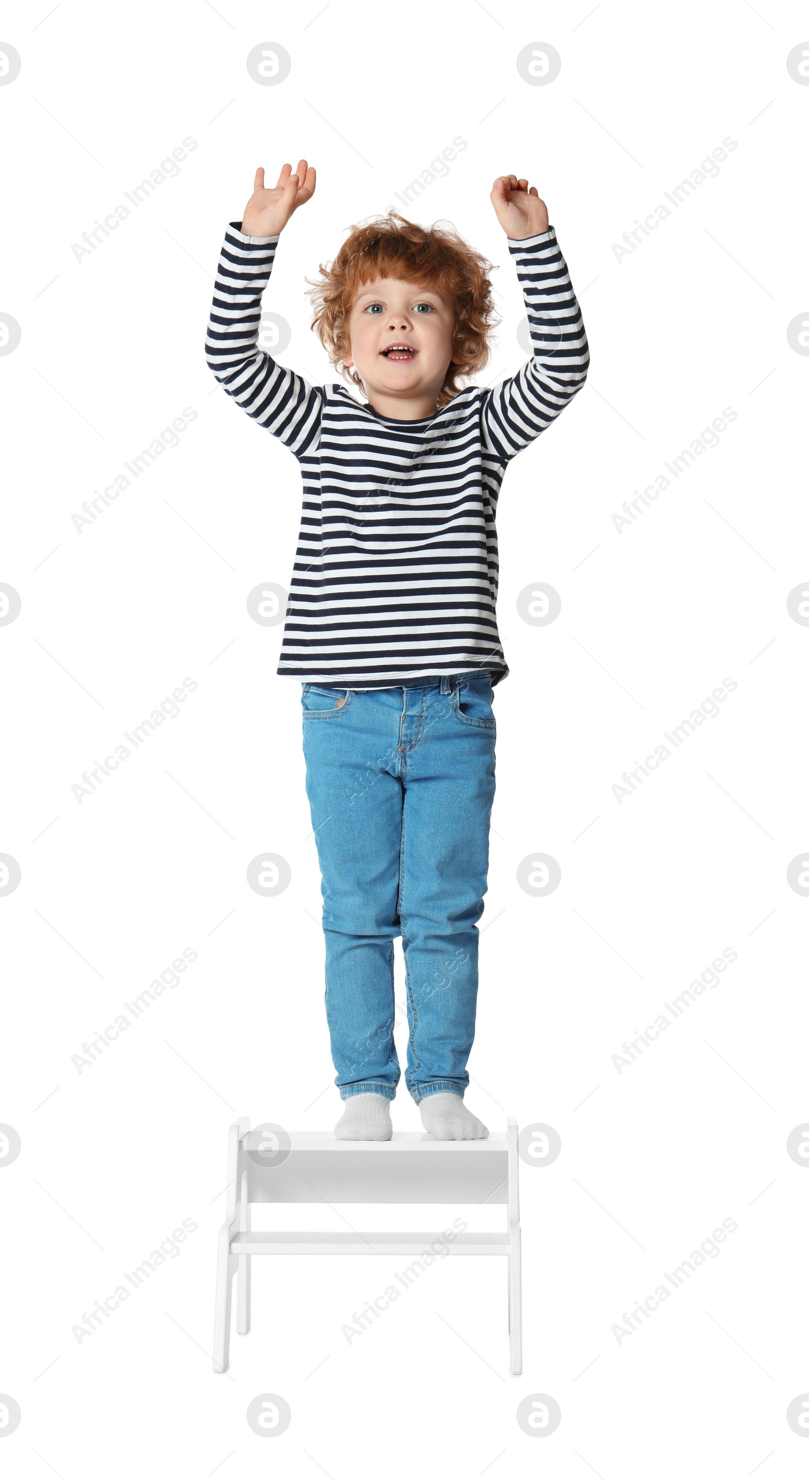 Photo of Little boy standing on step stool against white background