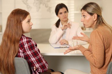 Difficult teenager. Mother and daughter having consultation with psychologist in office, selective focus