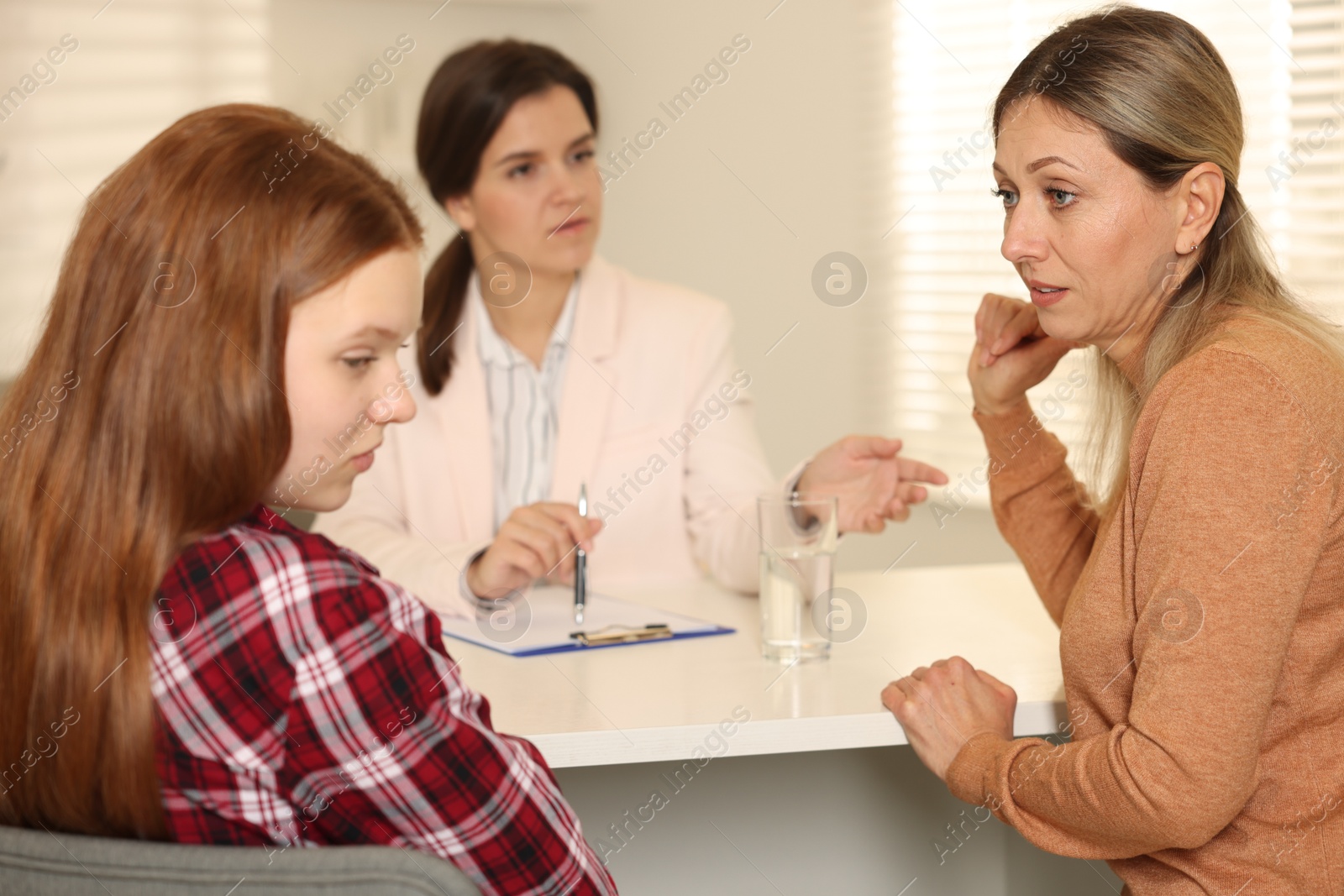 Photo of Difficult teenager. Mother and daughter having consultation with psychologist in office, selective focus