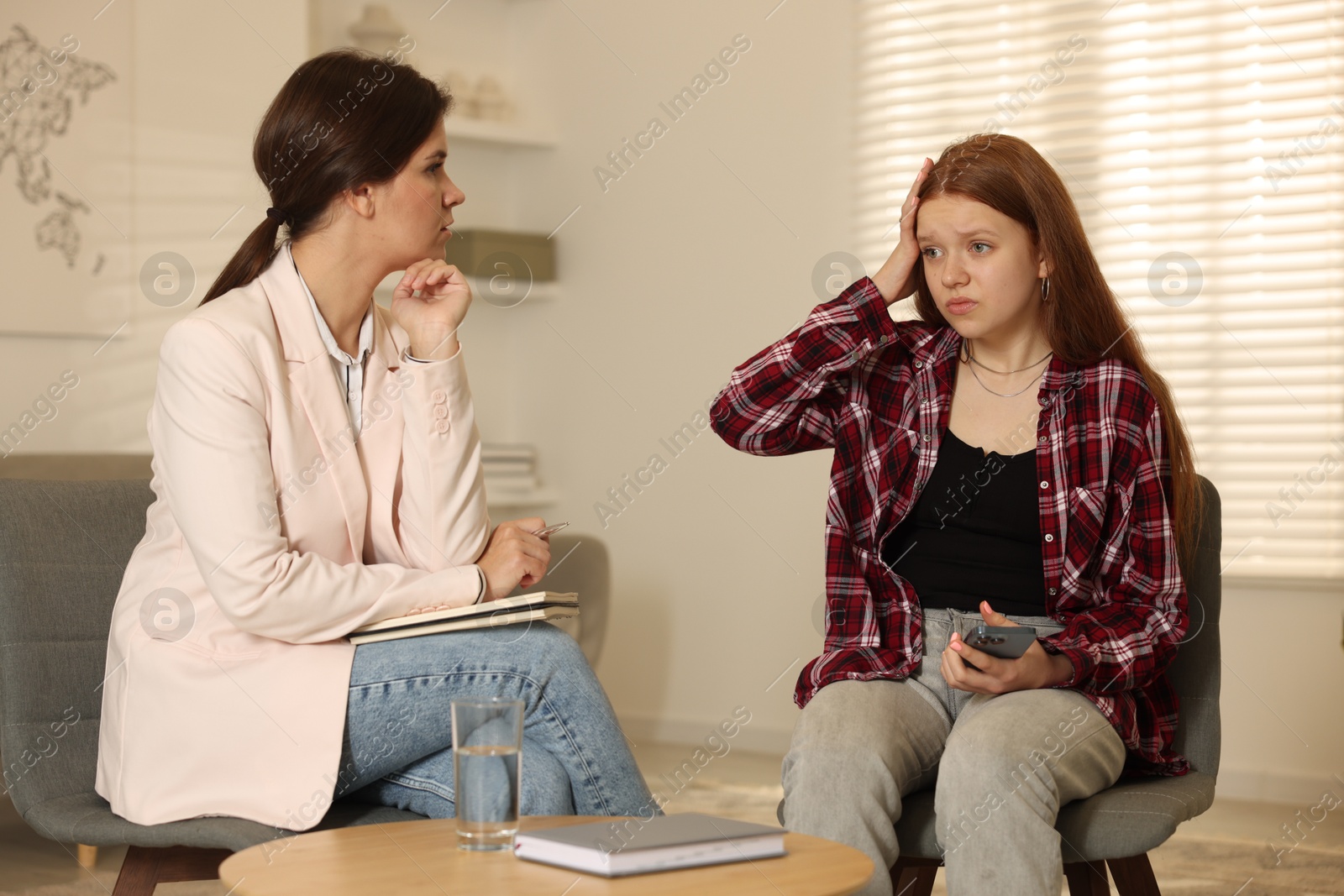 Photo of Psychologist working with difficult teenage girl in office